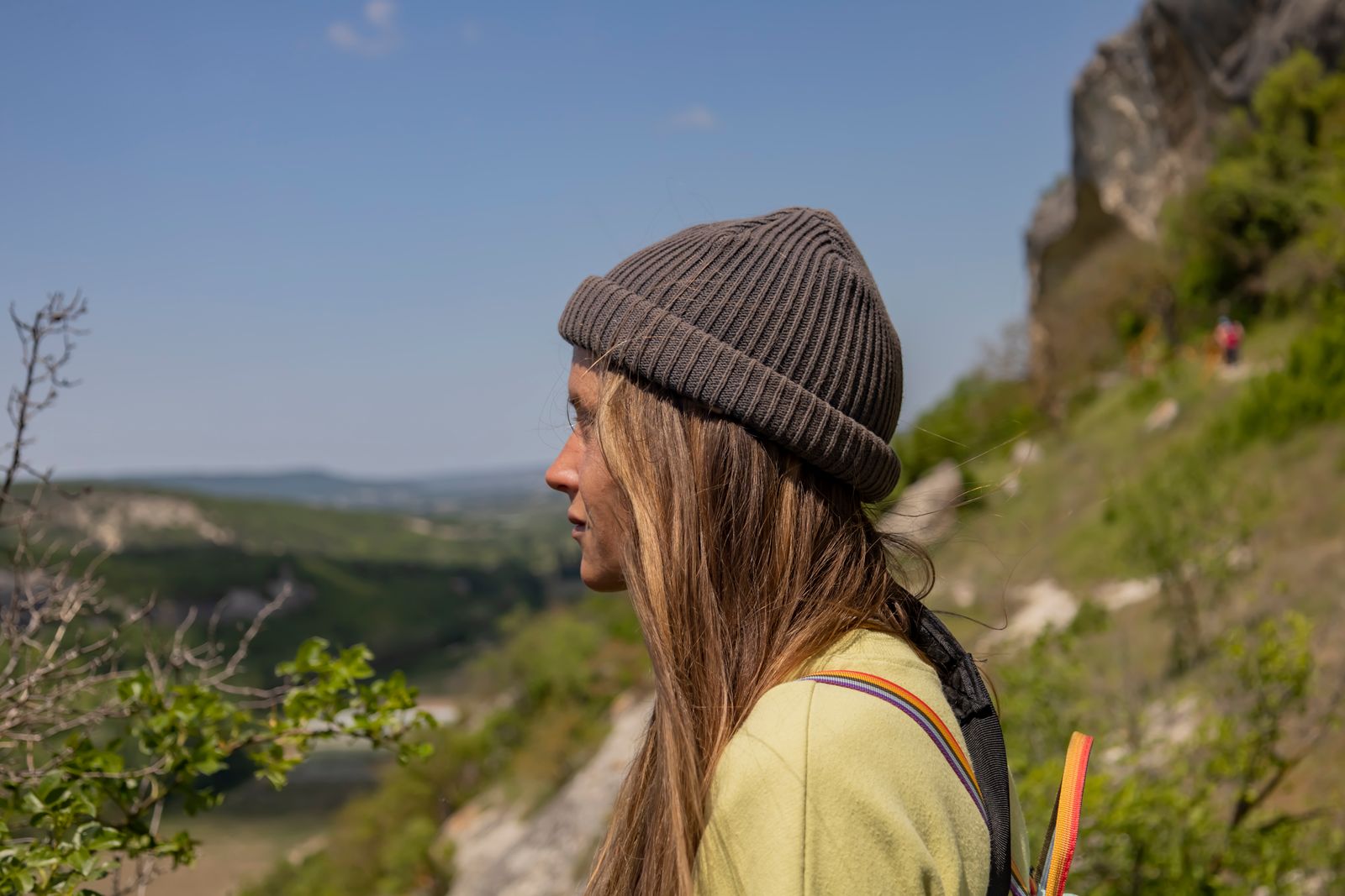 Woman in a sun hat enjoying a sunny mountain hike, the conditions the best hiking hats are made for