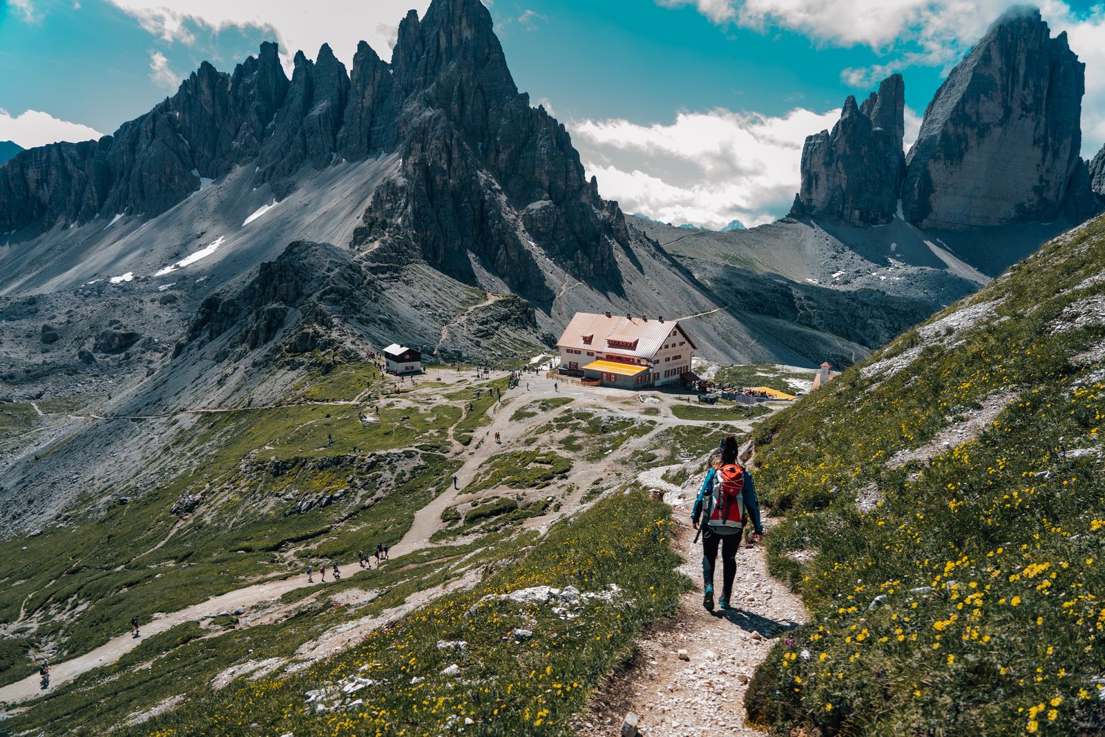 Woman hiking a dirt path in the Dolomites, a route where the best hiking shorts need stretch and good pockets
