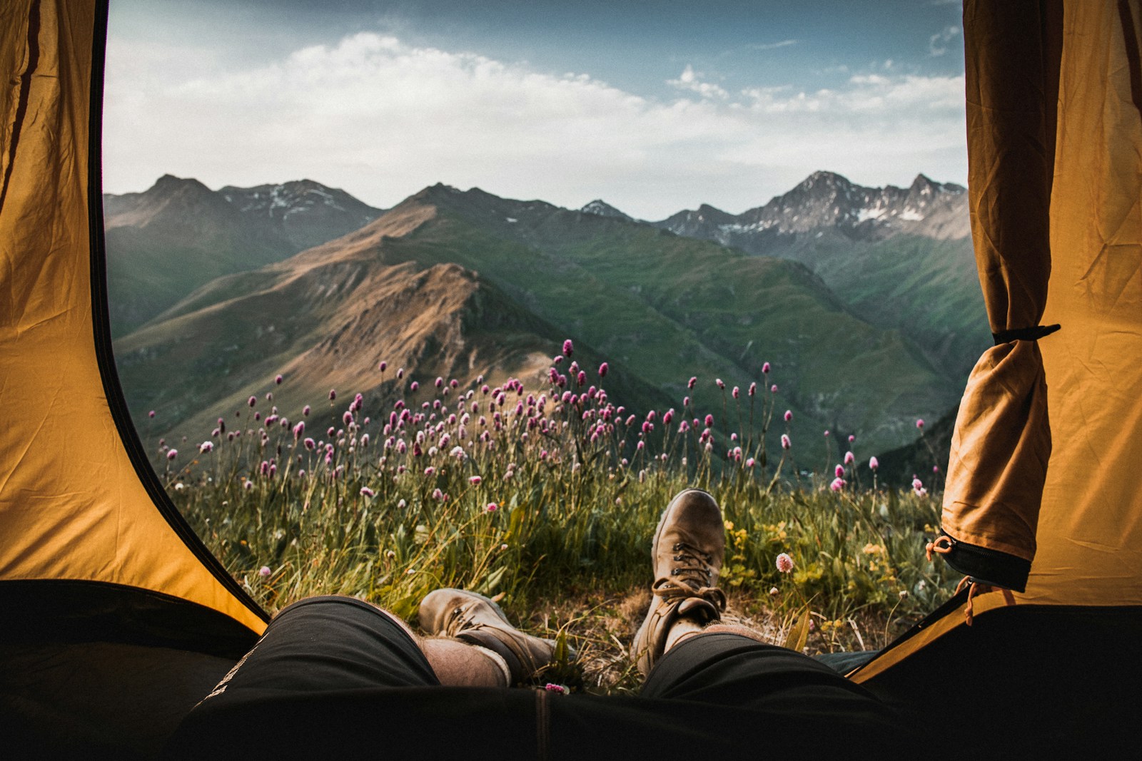 Hiker resting inside a tent looking out at mountains, a lifestyle moment Blackdog targets
