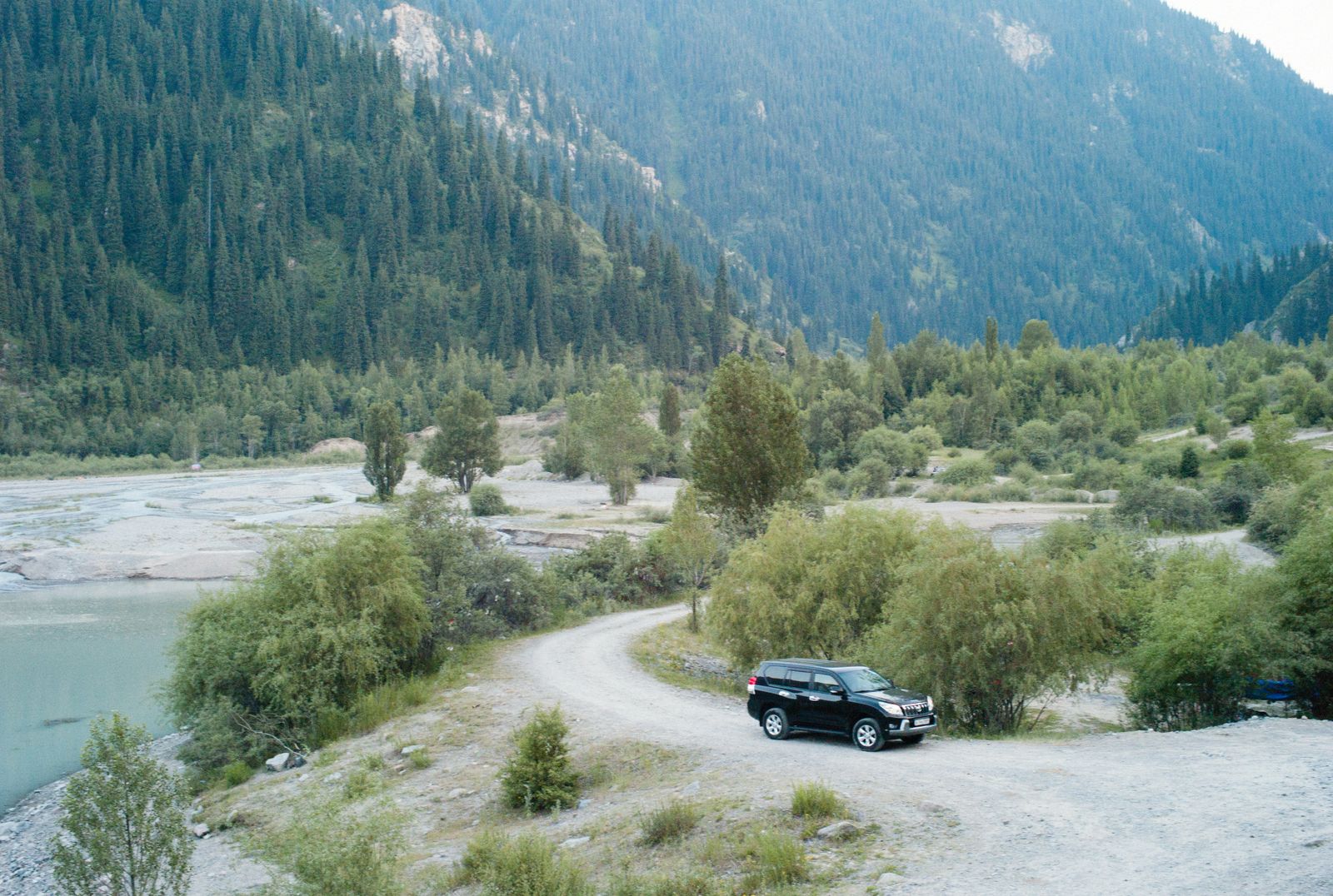 Black SUV on a winding mountain dirt road on the way to a car hiking trailhead