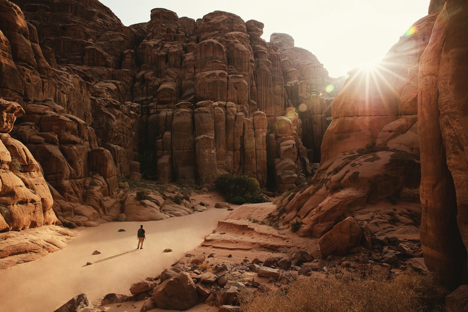 Hiker in a hat walking through a sunny desert canyon, where hiking hats need a wide brim