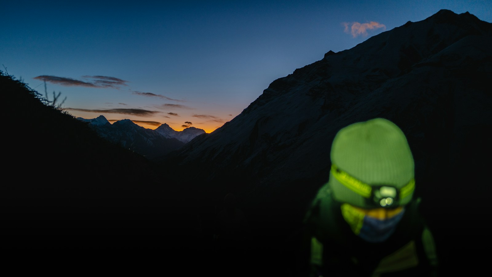 Hiking headlamp lighting the way for a hiker at dusk in the mountains