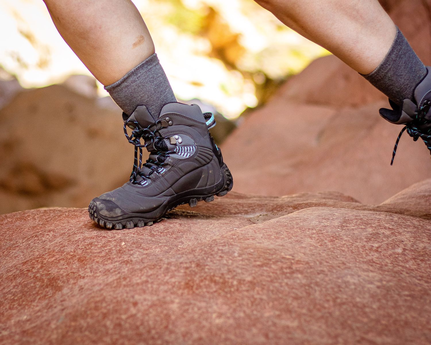 Close-up of hiking boots on a rocky trail, where LED hiking boots show ground texture best