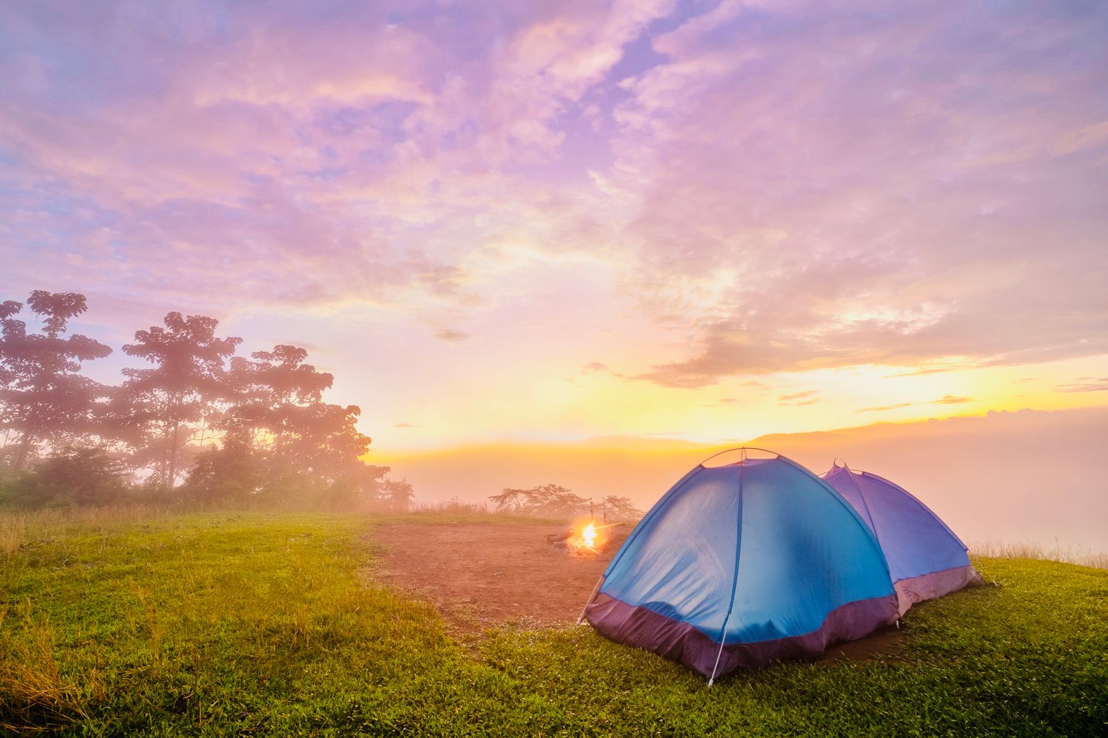 Lightweight tents on a grassy hill at sunrise, the kind of pitch Naturehike tents are designed for