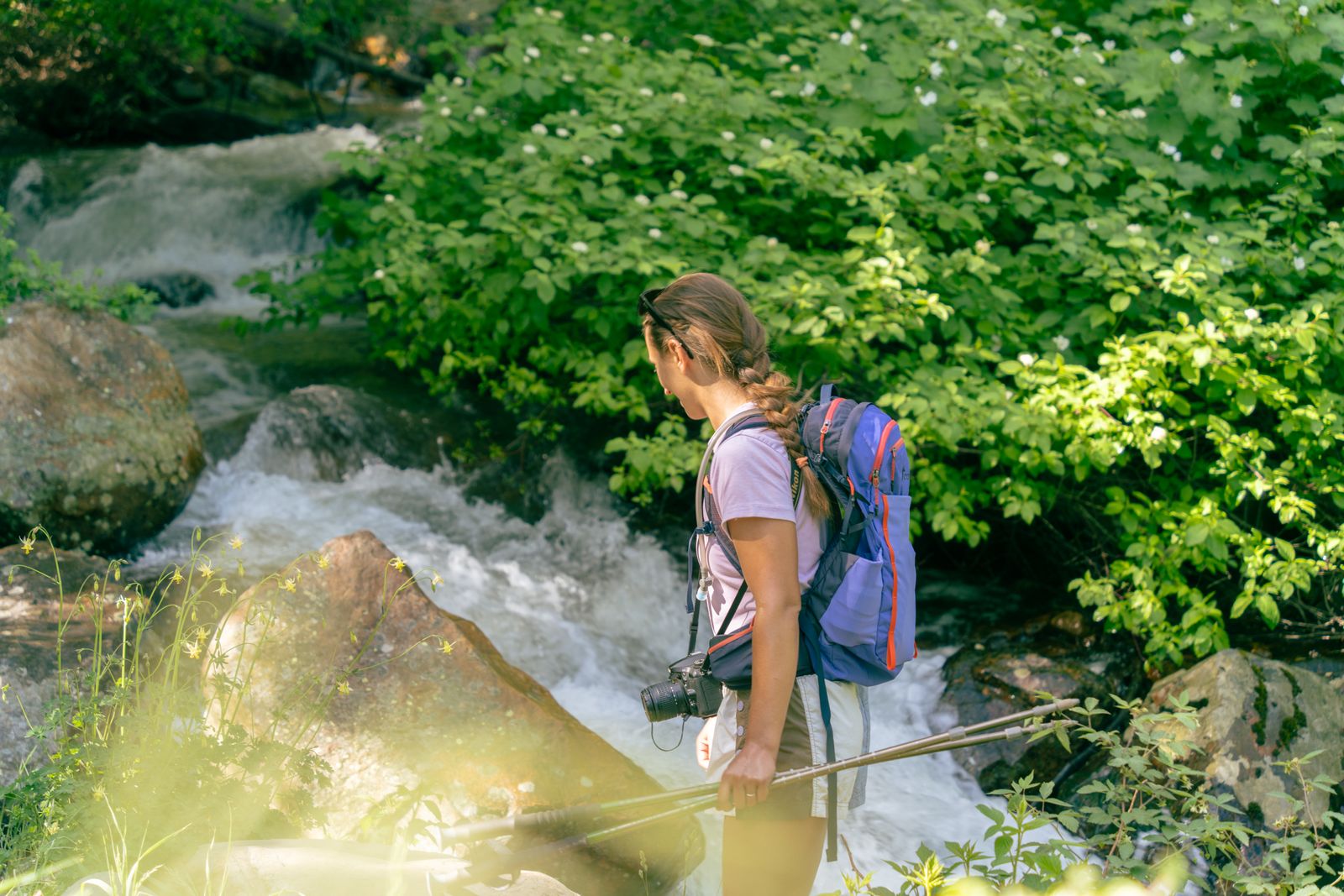 Woman exploring a mountain stream on a summer hike in Big Cottonwood Canyon, where quick-dry womens hiking shorts help